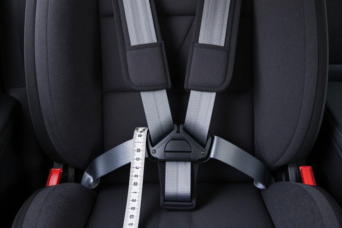Car seat chest clip at correct armpit-level position with measurement reference