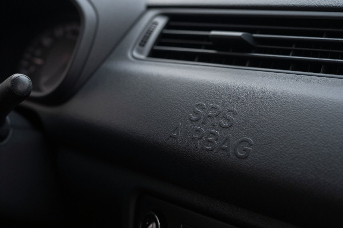 Vehicle dashboard showing passenger airbag compartment with SRS AIRBAG marking