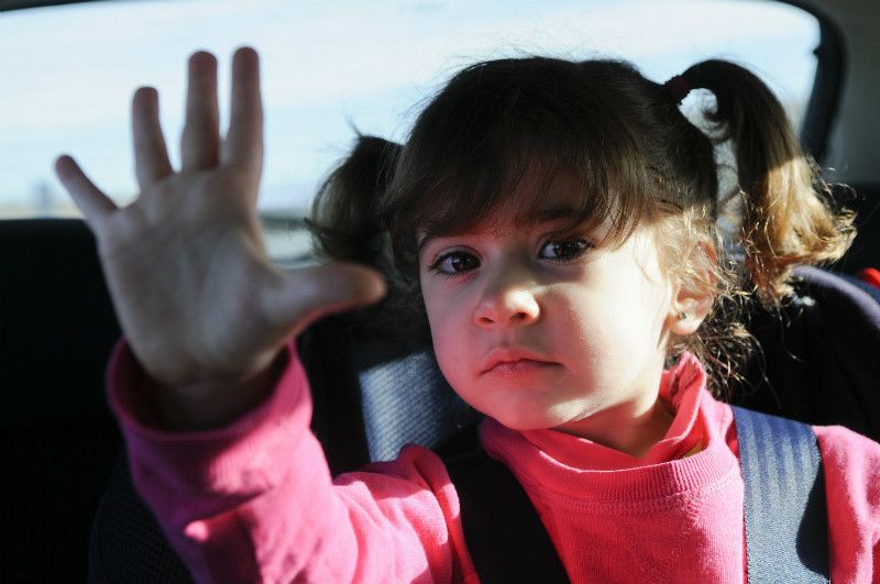 Child properly seated in booster seat with seat belt